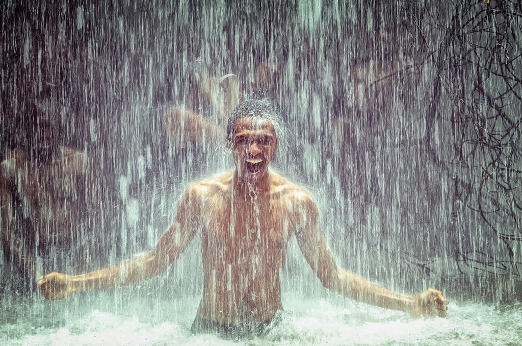 hidroterapia-fria-resiliencia-bio-yin Hombre bajo una cascada de agua fría activando su sistema nervioso simpático para combatir la depresión y el sedentarismo.