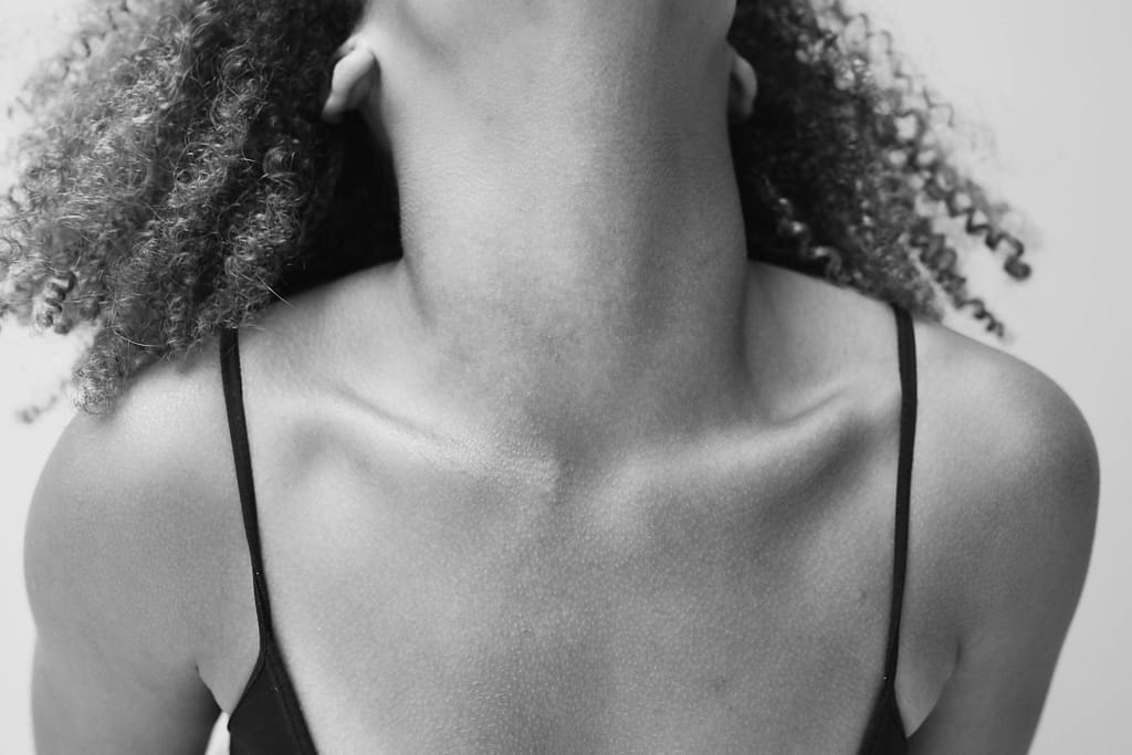 grasa-parda-ubicacion-supraclavicular Primer plano de la zona supraclavicular y el cuello de una mujer, resaltando la estructura ósea de la clavícula para ilustrar la ubicación de la grasa parda.