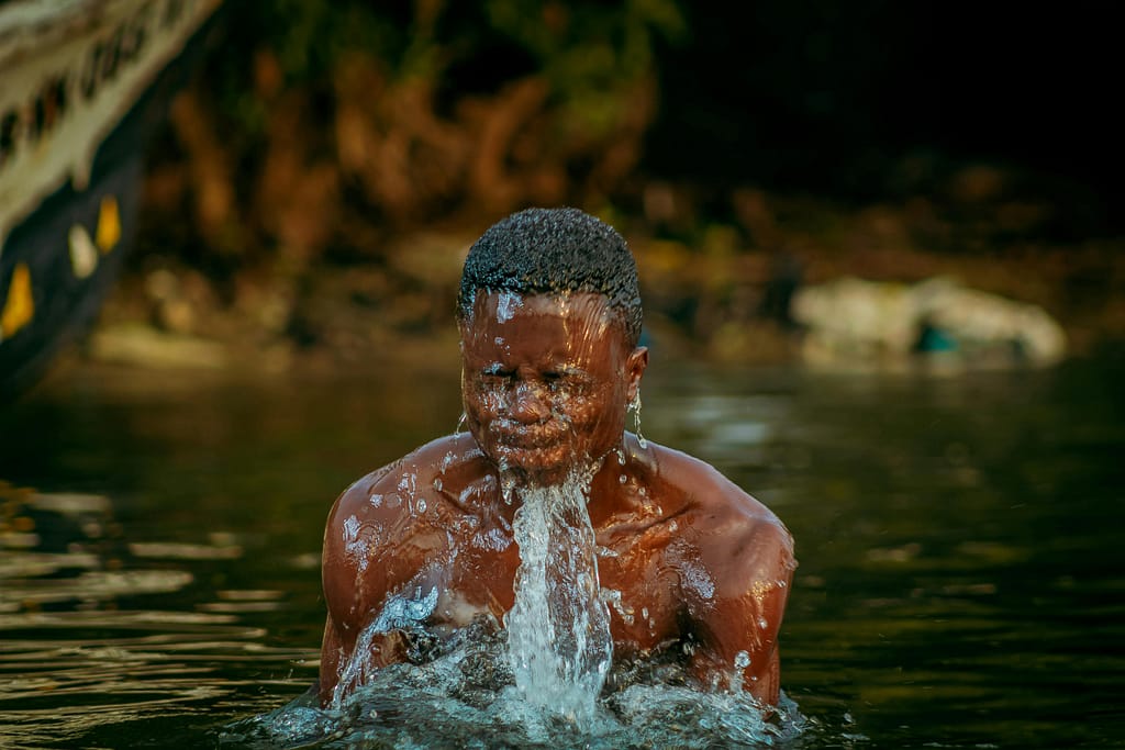 Resiliencia y terapia de frío Hombre emergiendo del agua con expresión de fortaleza y resiliencia.