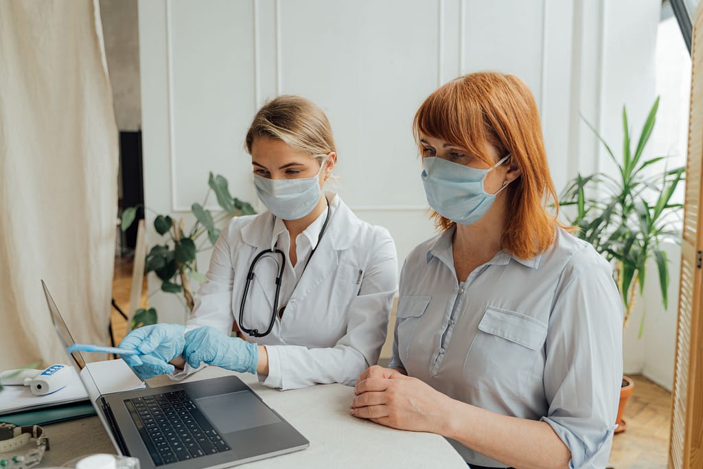 estudios-cientificos-evidencia-watsu Médica o investigadora analizando datos clínicos en una laptop junto a una paciente, ilustrando la evidencia científica y estudios sobre la técnica WATSU.