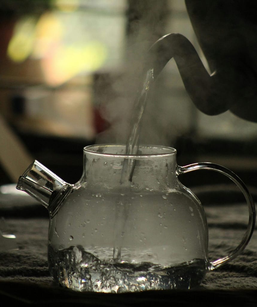 Método Sayu: El Arte Japonés del Agua Tibia y su Impacto en tu Fisiología Agua caliente hirviendo en una tetera de cristal para preparar el método Sayu japonés.