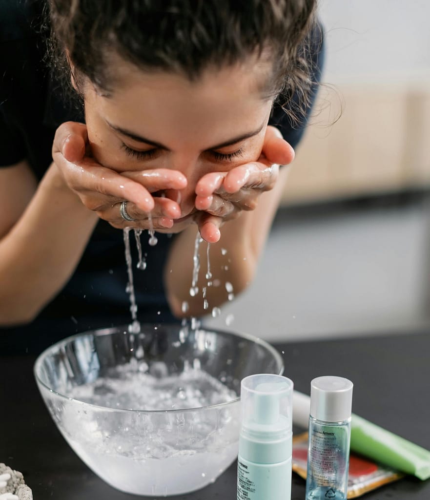 Inmersion-Facial-Hidroterapia Mujer lavándose el rostro con agua helada por la mañana para estimular el nervio vago.